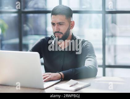 Bearded young businessman working on modern office. Consultant man thinking looking in monitor computer Stock Photo