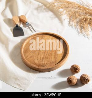 traditional handmade wooden plate with walnuts on the table Stock Photo
