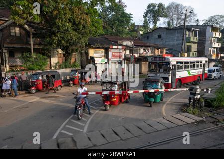 Sri Lanka. Level crossing (train crossing); rickshaw (tuk-tuk) taxis & tuk-tuk rank & bus; Kandy to Kadugannawa railway, near Henawala Danthure Road Stock Photo