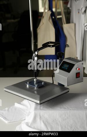 Printing logo. Heat press with t-shirt on white table Stock Photo