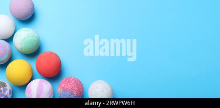 Many different bath bombs on light blue background, flat lay. Space for text Stock Photo