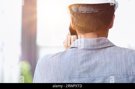 Rear view of young businessman talking on cell phone at the window Stock Photo