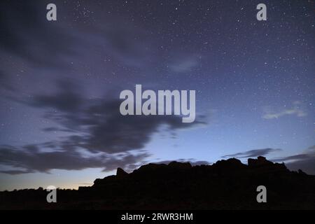 sky and stars over dark mountains at canyonlands national park Stock Photo