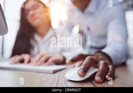 black man holding a computer mouse on the table, close-up Stock Photo