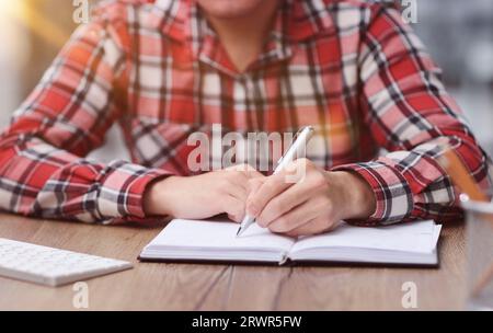 People write on a notepad and work in the office on a wooden table Stock Photo