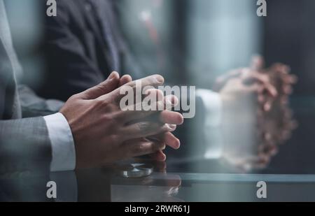 Manager listening to the report of colleagues sitting at the table in a dark office Stock Photo