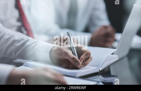 Close up of male hands , notebook and pen taking notes in business office Stock Photo
