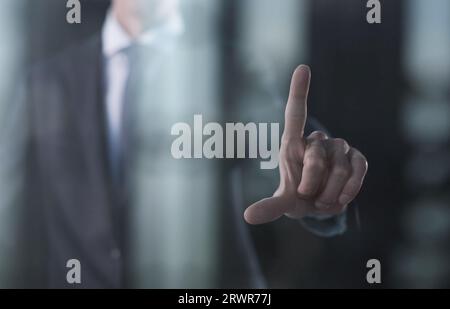 Business man pressing an imaginary button at his office. Stock Photo