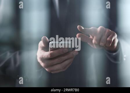 closeup of a businessman presses a finger on the smartphone screen. Stock Photo
