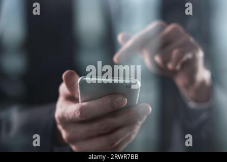 closeup of a businessman presses a finger on the smartphone screen. Stock Photo