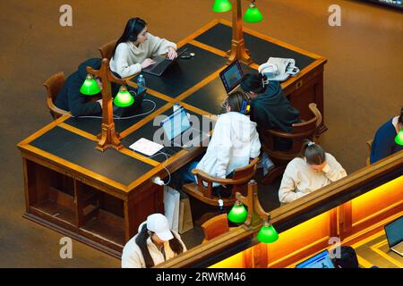 People studying on computers and laptops together in quiet room at Melbourne State Library, Victoria, Australia. Stock Photo