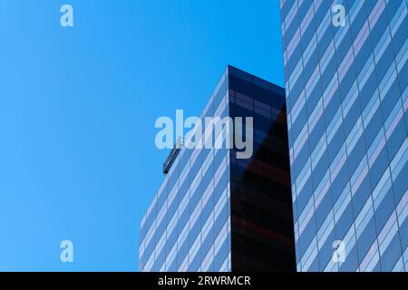 Abstract glass office building architecture showing horizontal lines and window patterns with blue sky background, Melbourne Australia. Stock Photo