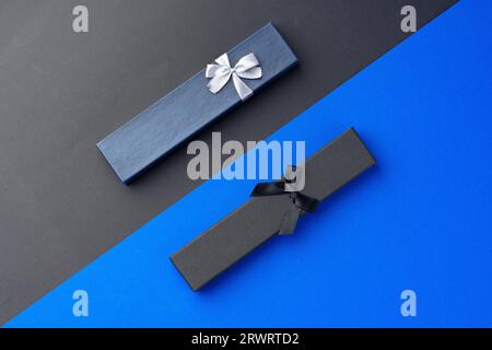 Two long jewelry boxes on black and blue background Stock Photo