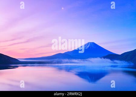 Reverse Fuji and the moon in the morning glow sky at Lake Motosu Stock Photo