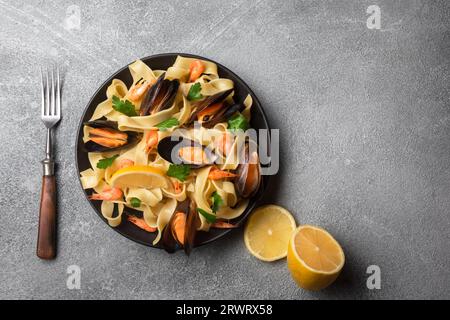 Traditional italian seafood pasta with clams Spaghetti alle Vongole on stone background. Top view. Stock Photo