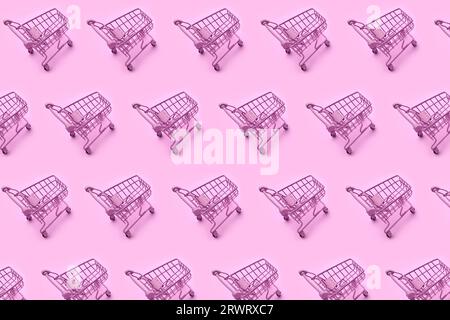 Mini shopping carts, mini shopping carts creative pattern background, top view, isolated on pink. High quality photo Stock Photo
