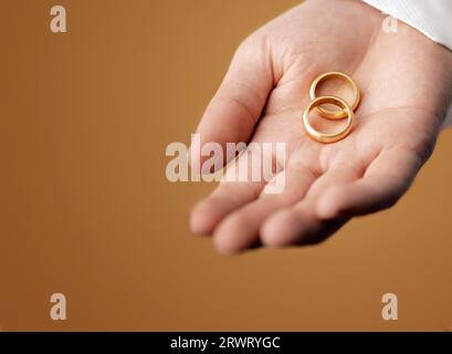 Man holding 100 year old gold wedding rings in his hand Stock Photo