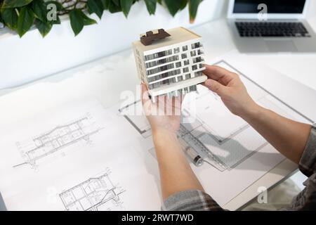Man with house model printed with 3D printer in light office of creative lab. Stock Photo