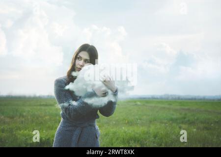 magical surreal moment of a woman warmly hugging a cloud Stock Photo