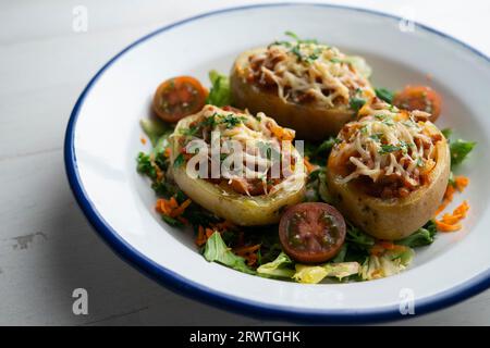 Potatoes stuffed with minced meat and tomato and baked in the oven with cheese. Stock Photo