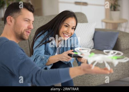 couple is operating a drone at home Stock Photo