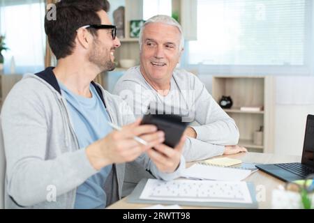 man helping senior neighbor with paperwork Stock Photo