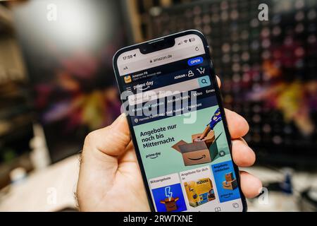 Paris, France - Jul 12, 2023: A male hand holds an Apple iPhone 15 Pro, displaying the German Amazon webpage that invites users to shop during the Prime Day event Stock Photo