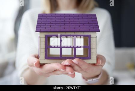 Woman holding toy wooden house in her hands Stock Photo