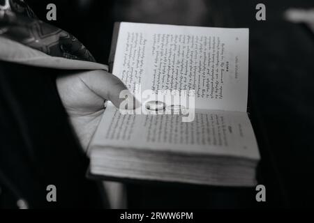 A person is holding a book featuring two metal rings on its spine Stock Photo