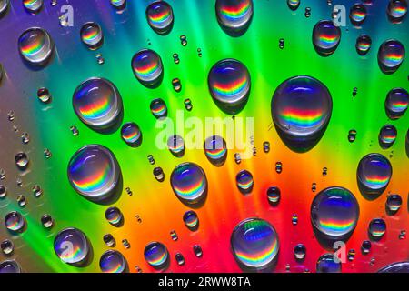 Brilliant rainbow of colors on metallic surface and inside water droplets background asset Stock Photo