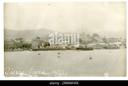 View from on board ship of the coastline and harbour of Freetown, Sierra Leone, showing dockside buildings and the hills rising behind.  Captioned in the negative: Sierra Leone. 15/3/19. Stock Photo