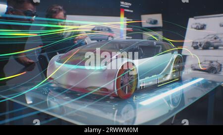 Two automotive engineers check aerodynamics of new electric car using futuristic augmented reality holographic automobile prototype. 3D computer graphics of vehicle high-tech developing and testing. Stock Photo