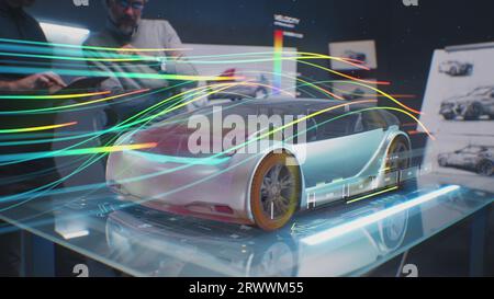 Two automotive engineers check aerodynamics of new electric car using futuristic augmented reality holographic automobile prototype. 3D computer graphics of vehicle high-tech developing and testing. Stock Photo