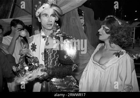 Andrew Logan dressed as half man half woman, (two half's of a whole) he is the artist and organiser of The Alternative Miss World a pansexual beauty pageant competition with actress Fenella Fielding, (1927-2018)  Backstage he is holding the Crown that he will place on the head of the winner. Olympia, West London 1981. 1980s UK HOMER SYKES Stock Photo