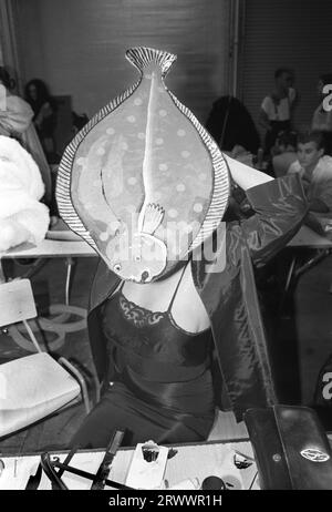 1980s UK. Young adult contestant at the Alternative Miss World beauty pageant, she makes last minute adjustments to her right-eyed flounder, a European plaice hat. Grand Hall, Olympia, West London England 1981. 1980s UK HOMER SYKES Stock Photo