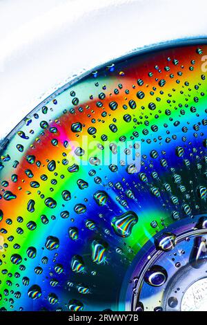 Abstract close up of CD with rainbow colors on metallic surface with bubbles Stock Photo