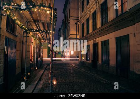 Empty alley amidst buildings in city at night Stock Photo