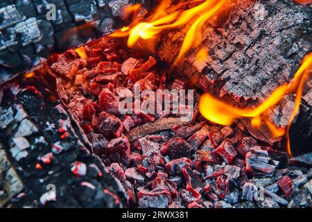 Macro view glowing red embers with yellow and orange flames background asset Stock Photo