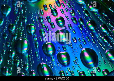 Close up of raindrops with blue and purple and green on reflective metallic background asset Stock Photo