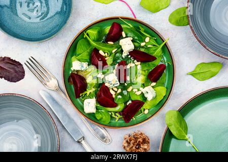 Meatless salad with boiled beetroot, blue cheese, greens and nuts on gray background Stock Photo