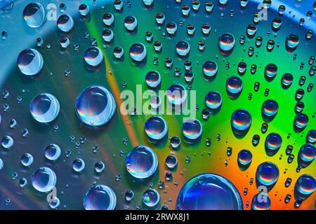 Blue bubbles on colorful metallic surface of green and orange abstract background asset Stock Photo