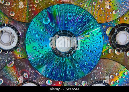 Macro of vibrant blue CD surface with water drops stacked on top of pile of CDs abstract art Stock Photo
