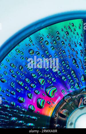 Gorgeous blue and green with burst of pink and orange on metallic surface with water drops Stock Photo