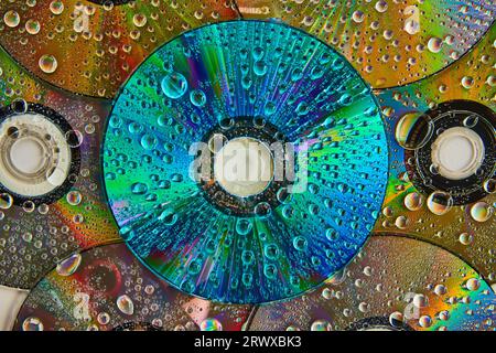 Colorful and vibrant blue CD surface with water drops stacked on top of pile of CDs abstract art Stock Photo