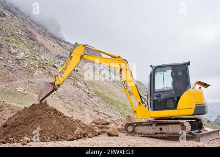 Excavator works in the highlands. Makes a trench for communications ...