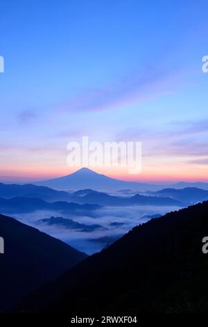 Mt. Fuji seen beyond the sea of clouds and mountain range Stock Photo