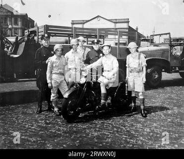 Before the New York parade, a group of British soldiers and American cops. Rare photograph: From a collection compiled by an unknown British serviceman covering the No. 1 Composite Demonstration, AA Battery, tour of the USA, from July 11th 1943. This is one from over one hundred images in the collection which were on average around 4x3 inches. Stock Photo