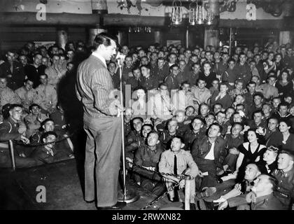 Cary Grant on stage, addressing British troops, Hollywood. Rare photograph: From a collection compiled by an unknown British serviceman covering the No. 1 Composite Demonstration, AA Battery, tour of the USA, from July 11th 1943. This is one from over one hundred images in the collection which were on average around 4x3 inches. Stock Photo