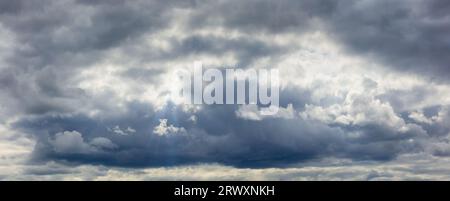 Cumuliform cloudscape before the rain. Dramatic dark sky background. The sun is hidden. Stock Photo