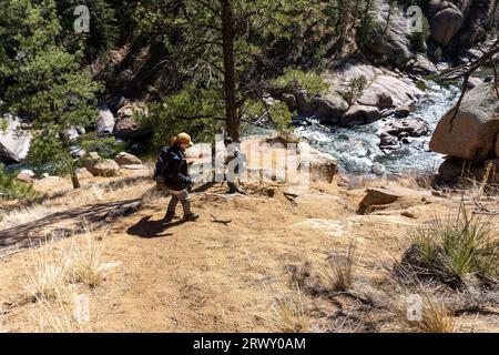 Man and woman walking down to river in Colorado Stock Photo